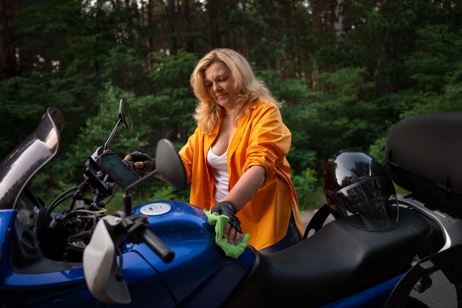 Woman cleaning her motorbike 